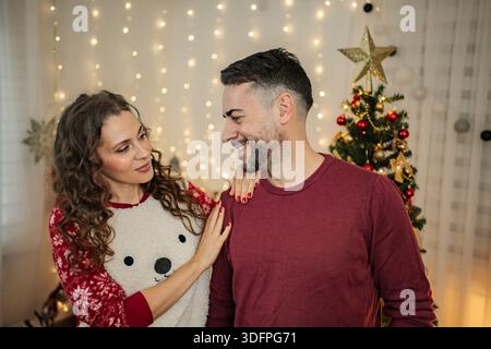 Ein Paar feiert Weihnachtsfeiertage und teilt liebevolle Momente mit einem Lächeln Stockfoto