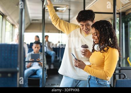 Glücklich asiatische Kerl und schwarze Dame nehmen Bus zusammen Stockfoto