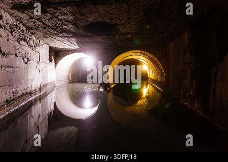 Zwei Kanalleitungen, die mit einem großen Abwasser- und Abflusswassersammler verbunden sind. Stockfoto