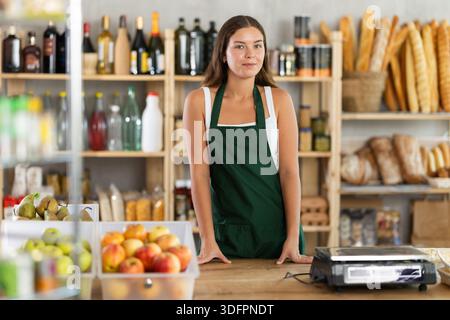 Porträt einer lächelnden Verkäuferin auf der Schürze hinter dem Supermarkt Stockfoto