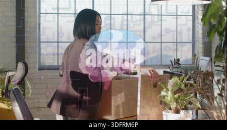 Die asiatische Frau im dunklen Blazer sortierte Kartons auf Holztisch im Loft, mit Pflanzen Stockfoto