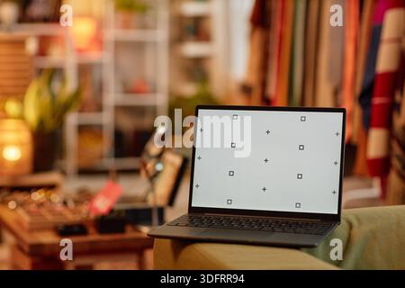 Laptop mit leerem Bildschirm im Second Hand Clothing Store Stockfoto