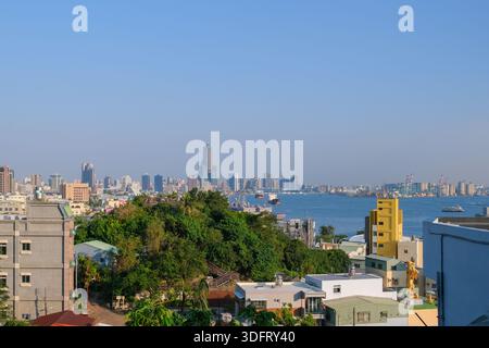 Panoramablick von einem Hügel aus mit Blick auf Kaohsiung City, Taiwan, mit urbaner Zersiedelung, Hochhäusern und umliegendem Grün. Stockfoto