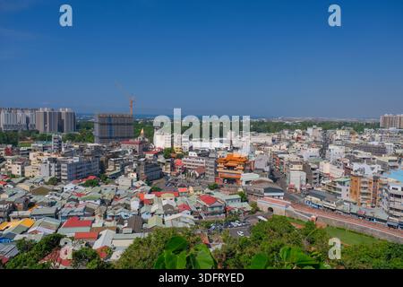 Panoramablick von einem Hügel aus mit Blick auf Kaohsiung City, Taiwan, mit urbaner Zersiedelung, Hochhäusern und umliegendem Grün. Stockfoto