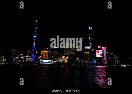 Atemberaubender Panoramablick bei Nacht auf die Skyline von Shanghai Pudong über den Huangpu River. Der ikonische Oriental Pearl Tower dominiert die Szene Stockfoto