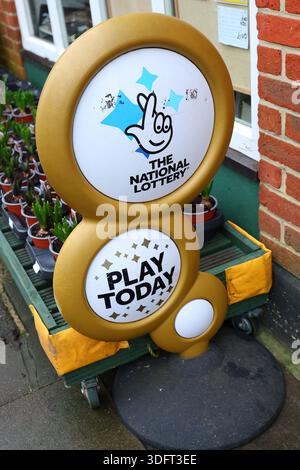 Das National Lottery oder Lotto Play Today Gold-Zeichen vor einem Zeitungsgeschäft in Chichester, West Sussex, Großbritannien. Stockfoto