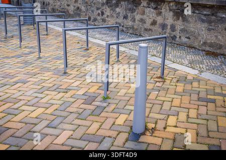 Leere Fahrradständer aus Metall säumen eine moderne Stadtstraße Stockfoto