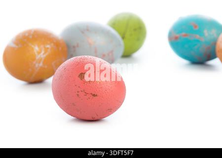 Farbenfrohe Eier, die auf einer glatten Oberfläche während einer festlichen Feier angeordnet werden Stockfoto