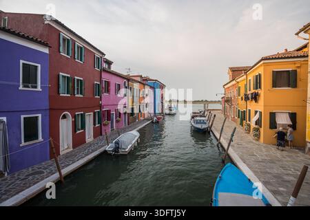 Farbenfrohe Kanalstraße auf der Insel Burano in der Nähe von Venedig mit lebhaften traditionellen Häusern, kleinen Booten, ruhigem Wasserweg und authentischer italienischer Lagune Stockfoto