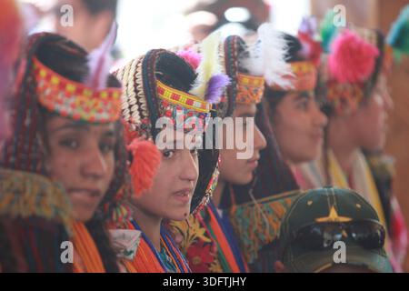 Kalash, Pakistan - 24. Dezember 2025: Blick auf Kalashi-Frauen in traditionellen Kleidern und Kopfbedeckungen, deren leuchtende Farben einen auffälligen Kontrast zum Th bilden Stockfoto