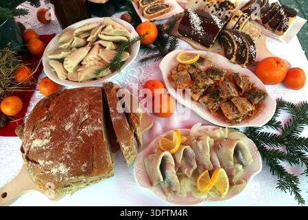 Krakau. Krakau. Polen. Traditionelle polnische Weihnachtsgerichte auf dem Tisch. Brot, Klöße, Heringe, Mohnkuchen, Käsekuchen. Stockfoto
