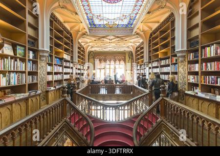 Porto, Portugal - 27. November 2017: Blick auf das kunstvoll verzierte Innere des Livraria Lello, wo warme Holztöne auf lebendige Bucheinbände unter Buntglas treffen Stockfoto