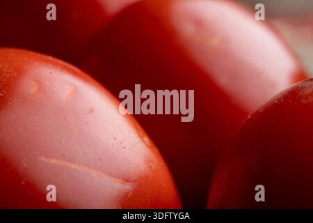 Extreme Makroaufnahme der leuchtenden roten Tomaten-Oberfläche. Hochwertiger Hintergrund aus biologischem Gemüse, der sich auf glatte Hautstruktur und helle Farbe konzentriert. Stockfoto
