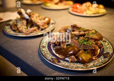 Herzhaftes und warmes, traditionelles Familienessen mit geröstetem Lamm und Kartoffeln. Genießen Sie ein warmes und angenehmes Familienmenü mit rustikalem geröstetem Lamm und Stockfoto