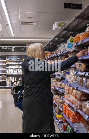 Frau, die Brot in einem Supermarkt kauft, Lebensmittel in einem Co-op-Supermarkt, Großbritannien Stockfoto