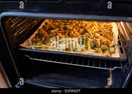 Nahaufnahme von köstlichem geröstetem Gemüse im Ofen auf Backblech für gesundes Kochen und Zubereitung von Mahlzeiten. Stockfoto