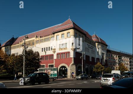 Targu Mures, Rumänien - 17. oktober 2025. Der berühmte Kulturpalast und der Turm des Alten Rathauses von Targu Mures, Rumänien, stehen an einer belebten Straße mit Bäumen unter einem hellblauen Himmel Stockfoto