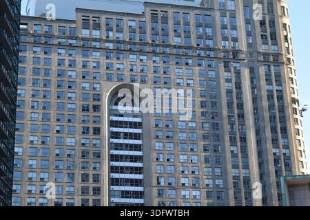 Hohes Wohngebäude mit sich wiederholenden Fenstern und großer bogenförmiger Öffnung in der Innenstadt von Toronto, Kanada. Stockfoto