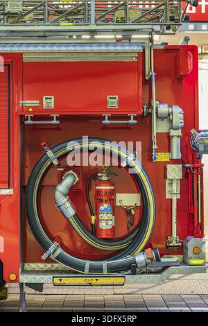 Rückansicht eines roten japanischen Feuerwehrwagens, ausgestattet mit einem gewickelten Feuerwehrschlauch und einem Feuerwehrtank, Chiyoda Ward, Japan Stockfoto