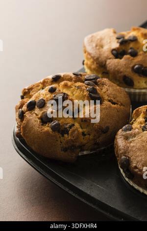 Frisch gebackene Schokoladen-Chip-Muffins in schwarzer Pfanne Stockfoto