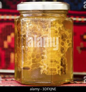 Gesunder natürlicher goldener Honig mit Kamm in einem Glasgefäß Stockfoto