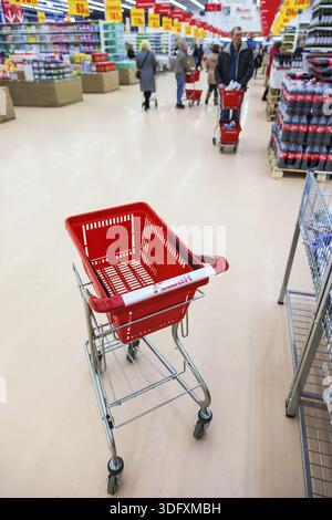 SAMARA, RUSSLAND - 8. MÄRZ 2015: Leerer roter Einkaufswagen im Innern des Auchan Stores. Das französische Vertriebsnetz Auchan vereint mehr als 1300 Geschäfte Stockfoto