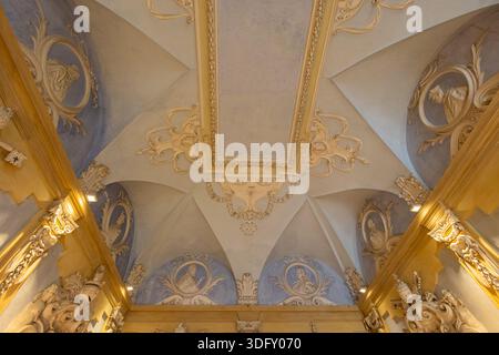 ISOLA BELLA, ITALIEN, 06.21.2025: Reich dekorierte Gewölbedecke mit pastellblauen Freskenmotiven und vergoldeten Zierleisten, die klassische Ornamente zeigen Stockfoto