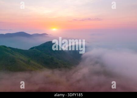 Morgenlicht von der Sonnenaufgang an der Küste mit Bergen und Hügeln, die von nassen Wolken und Nebel umhüllt sind, warme Sommertöne, die über dem Point View Landc liegen Stockfoto