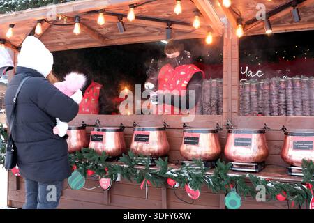An einem kühlen Tag genießen Besucher köstliche heiße Getränke an einem gemütlichen Marktstand. Kiew, Ukraine, Expozentrum der Ukraine. Januar 2026. Stockfoto