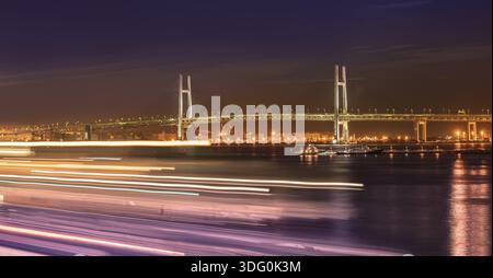 Panorama der Yokohama Bay Bridge vom osanbashi Pier mit Booten Geschwindigkeitslichtern im Stadtteil Minato Mirai von Yokohama mit Booten unter dem Nachthimmel, Stockfoto