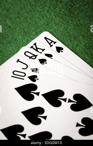 Piks gerade Flush Pokerkarten auf grünem Tisch Stockfoto
