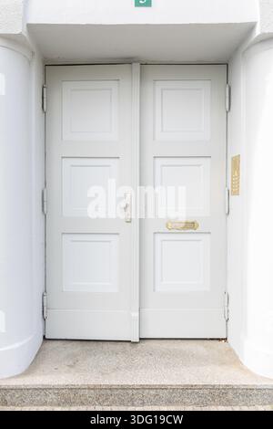 Helle Doppeleingangstür des modernen Hauses. Minimalistischer Stadteingang. Stockfoto