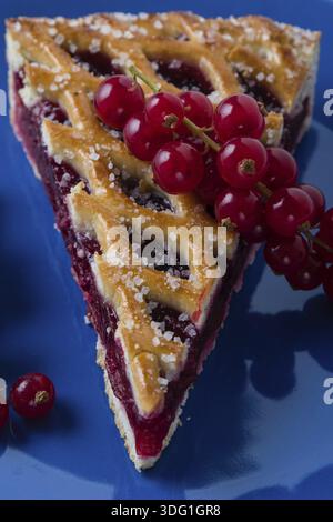 Frischer Kirschkuchen mit Johannisbeere auf blauem Teller Stockfoto