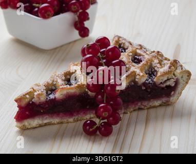 Frischer Kirschkuchen mit Johannisbeere auf Holztisch Stockfoto