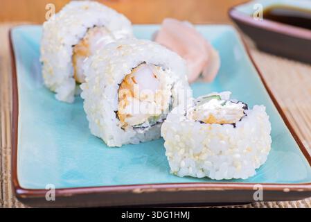 Kalifornisches Maki-Sushi mit Tempura-Garnelen. Brötchen aus Tempura-Garnelen, Frischkäse und Gurke. Geringe Schärfentiefe Stockfoto