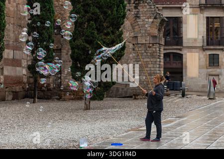 Barcelona, Spanien - 20. Oktober 2025: Ein Straßenkünstler, der riesige Seifenblasen auf der Plac de la Seu vor der Kathedrale von Barcelona macht. Stockfoto