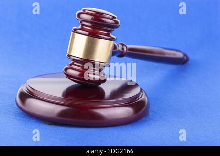 Hölzerner brauner Richter-Hammer auf blauem Hintergrund Stockfoto
