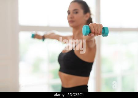 Sportliche Junge Frau Trainiert Mit Zwei Hanteln Stockfoto