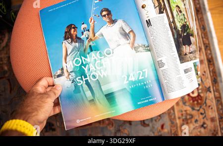Paris, Frankreich - 2. September 2025: POV Hand hält ein offenes Lifestyle-Magazin, das eine Monaco Yacht Show-Werbung vom 24. Bis 27. September 2025 zeigt Stockfoto