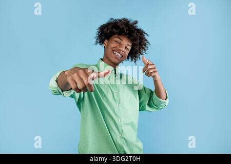 Sie sind dran. Fröhlicher afroamerikanischer Kerl, der mit den Fingern auf die Kamera zeigt und lächelt und dich vor blauem Hintergrund auswählt Stockfoto