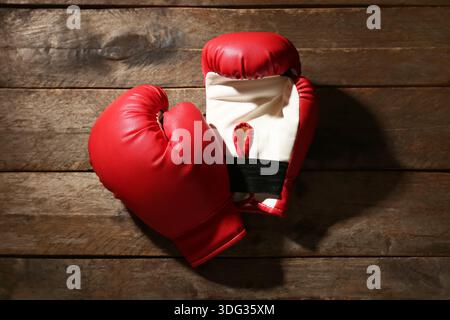 Paar rote Boxhandschuhe auf hölzernem Hintergrund Stockfoto