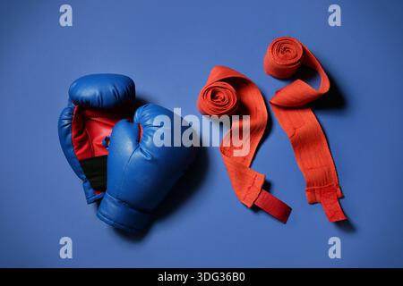 Boxhandschuhe mit Armbändern auf blauem Hintergrund Stockfoto
