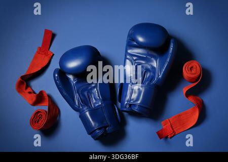 Boxhandschuhe mit Armbändern auf blauem Hintergrund Stockfoto