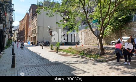 Montreal, QC, Kanada - 7. August 2025: Fußgänger erkunden die Rue du cUL-de-SAC, eine bezaubernde alte Straße in der historischen Altstadt von Quebec, die Architektur zeigt Stockfoto