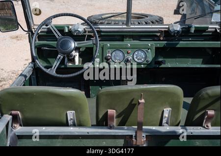 Innenansicht eines restaurierten grünen Land Rover Series I Cockpits mit zentralen Oldtimern, Zündschlüsseln, metallischem Armaturenbrett und drei Akros Stockfoto