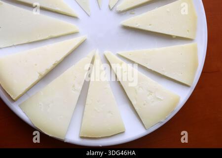 Handwerkliche Käsesorten mit natürlichen Texturen und in Scheiben geschnittenen Stücken Stockfoto