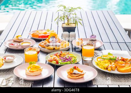 Luxuriöser Brunch auf der Terrasse am Pool mit frischem Obst, Stockfoto