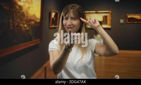 Die Frau zeigt den Finger nach vorne und zeigt die Punkte im Galeriebau nach oben, die Hände sind sichtbar und die Finger klingen; spielerische Neugier. Stockfoto