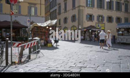 Straßenszene auf dem europäischen Marktplatz, verschwommener Kopfsteinpflastervordergrund und sanftes Bokeh an fernen Verkaufsständen und Fassaden; Hintergrund im Hintergrund: Ruhe im Hintergrund. Stockfoto
