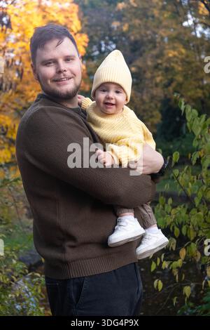 Vater und Baby genießen das Sonnenlicht im Herbst Stockfoto